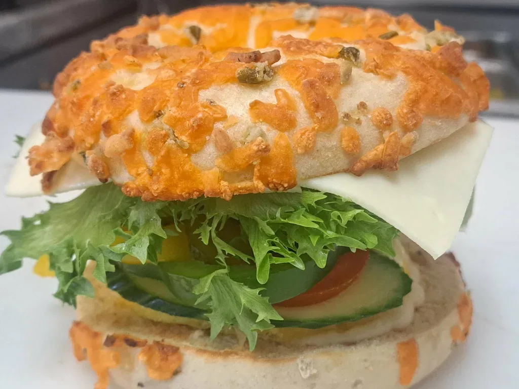 Sandwich on a jalapeño cheese bagel with lettuce, tomato and cucumber